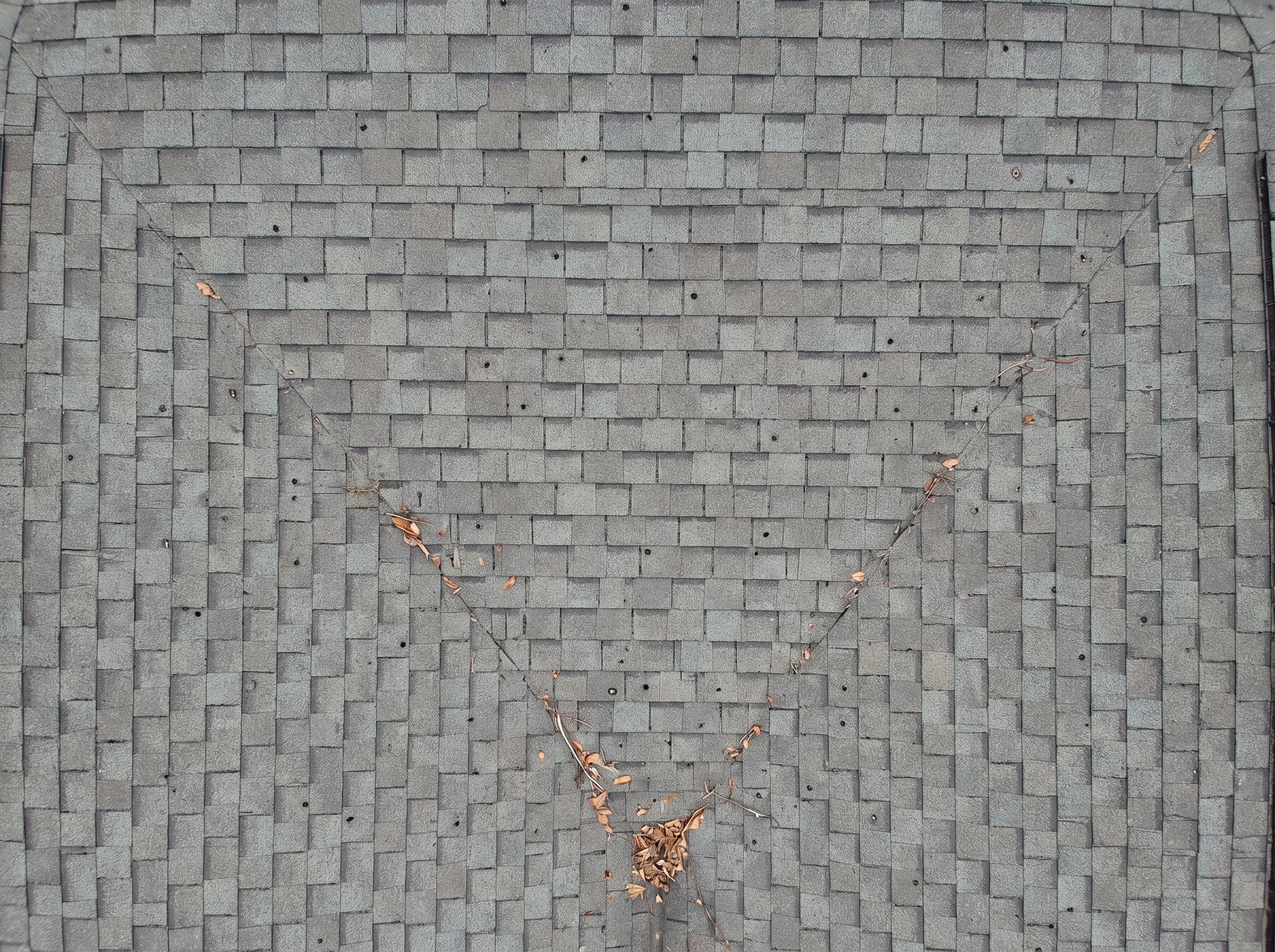 Straight-down aerial view of hail impact on an asphalt shingle roof